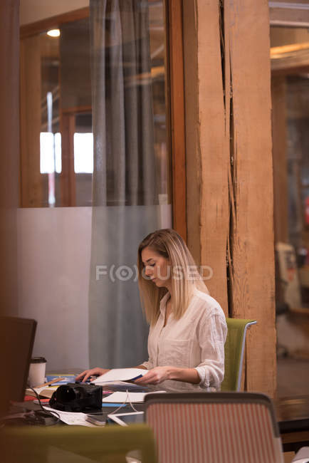 Ejecutiva femenina trabajando en el escritorio en la oficina - foto de stock