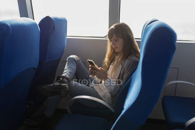 Красивая женщина с помощью мобильного телефона в круизном лайнере — стоковое фото