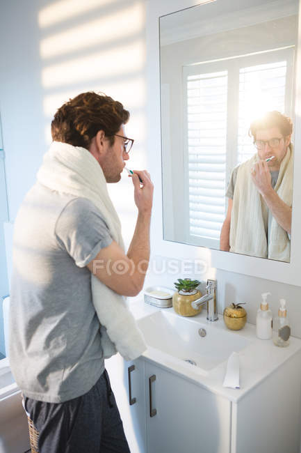 Homem escovando os dentes no banheiro em casa — Fotografia de Stock