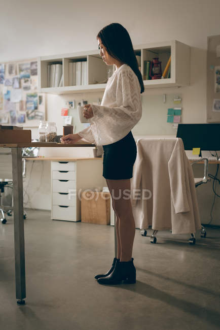 Жіночий керівник має чашку кави в офісі — стокове фото