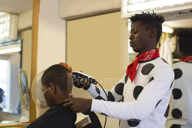 Barber coupe les cheveux du client dans le salon de coiffure — Photo de stock
