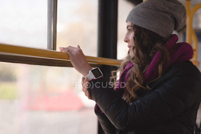 Jovem mulher olhando através da janela enquanto viaja em trem — Fotografia de Stock