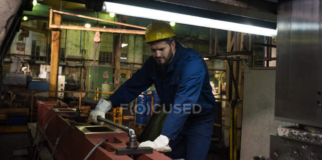 Technician in protective work wear cutting metal in industry — Stock Photo