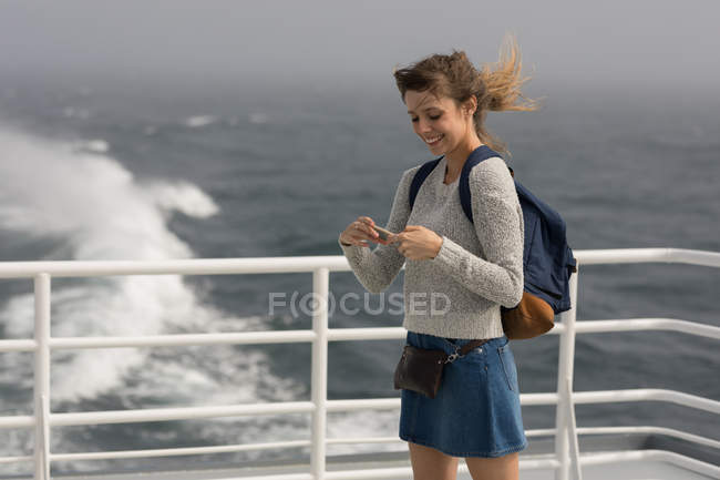 Femme utilisant un téléphone portable téléphone portable sur un bateau de croisière — Photo de stock