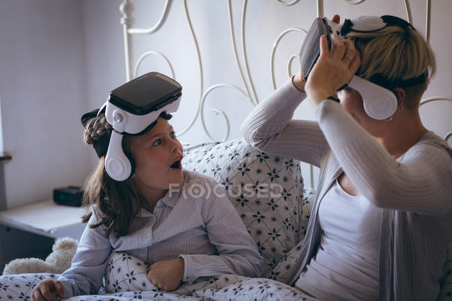 Aufgeregtes Mädchen schaut ihre Mutter zu Hause im Bett an — Stockfoto