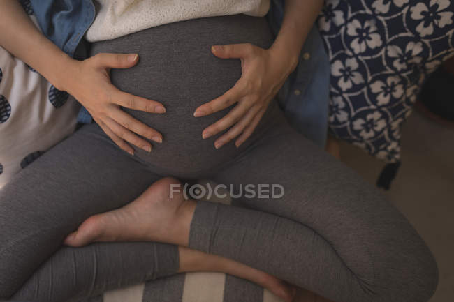Беременная деловая женщина трогает живот в кафе — стоковое фото