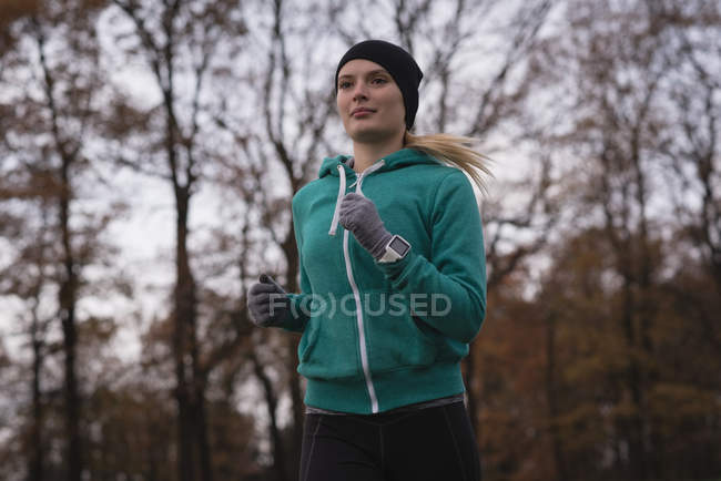 Jeune femme jogging dans le parc — Photo de stock