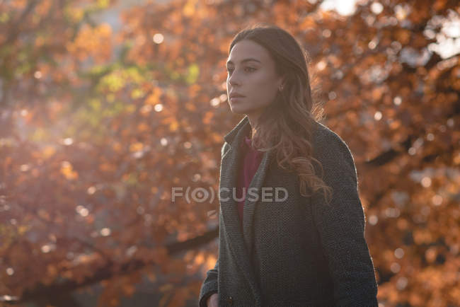 Thoughtful woman walking in park on a sunny day — Stock Photo