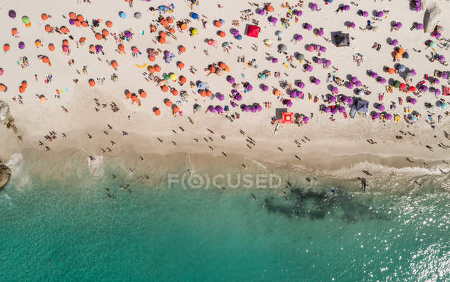 Вид з повітря на туристичні сонячні ванни на пляжі в сонячний день — стокове фото
