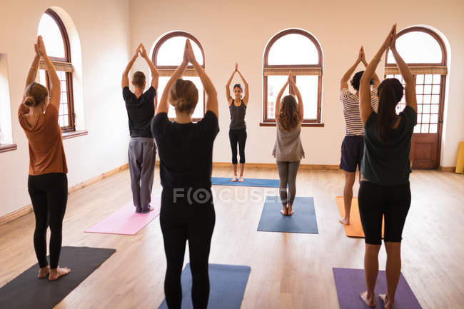 Group of people performing yoga exercise together in fitness club — Stock Photo