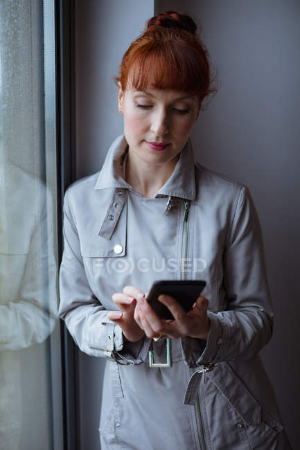 Бизнесвумен, использующая мобильный телефон в номере отеля — стоковое фото