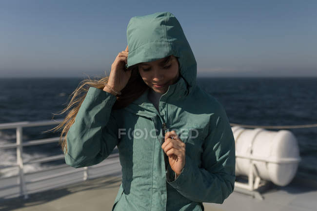 Beautiful woman in hoodie standing on cruise ship — Stock Photo
