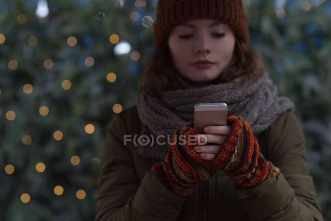 Красива жінка в зимовому одязі за допомогою мобільного телефону — стокове фото