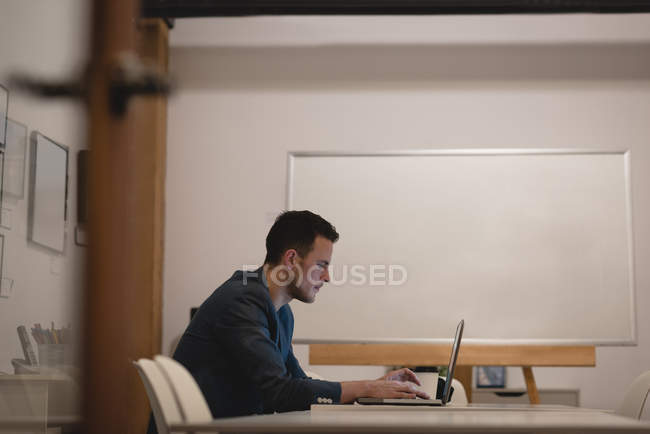 Homme d'affaires utilisant un ordinateur portable dans la salle de conférence au bureau — Photo de stock
