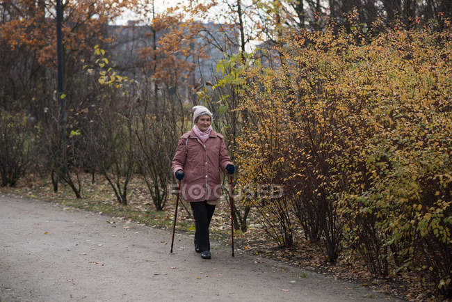 Donna anziana attiva camminando all'aperto — Foto stock