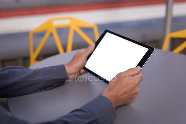 Primo piano dell'uomo d'affari che utilizza tablet digitale nei locali dell'hotel — Foto stock