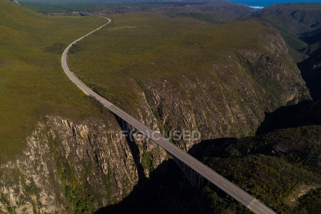 Aerial view of bridge over mountain on a sunny day — Stock Photo