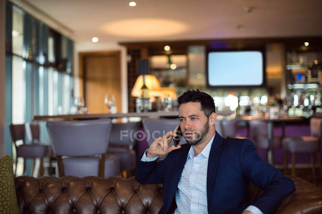 Бизнесмен разговаривает по мобильному телефону в отеле — стоковое фото