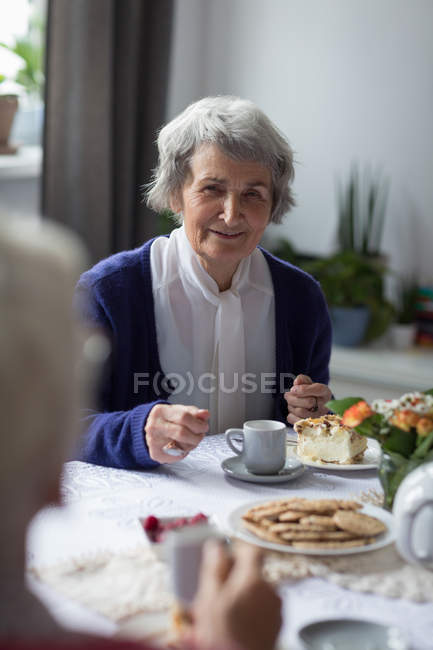 Senior friends interacting witch each other while having breakfast at home — Stock Photo