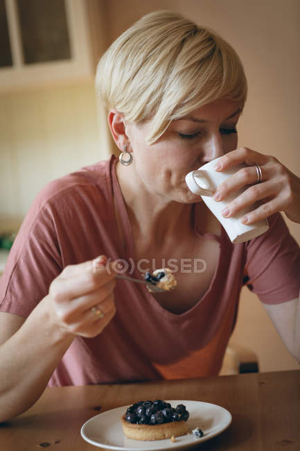 Close-up de mulher tomando café da manhã à mesa — Fotografia de Stock