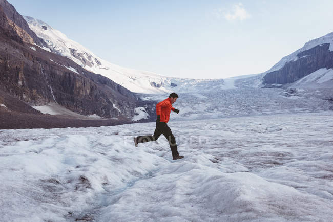 Homem caminhando em uma paisagem de neve durante o inverno — Fotografia de Stock