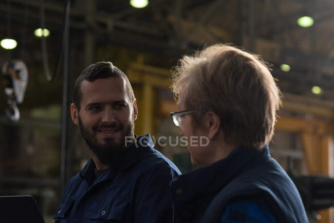 Technicians interacting with each other in metal industry — Stock Photo