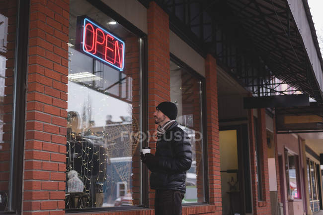 Jovem olhando para vitrine da loja — Fotografia de Stock