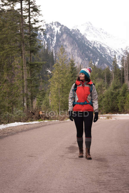 Nachdenkliche Frau im Winter mit Rucksack unterwegs — Stockfoto