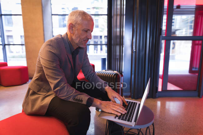 Бізнесмен використовує ноутбук у вестибюлі в готелі — стокове фото