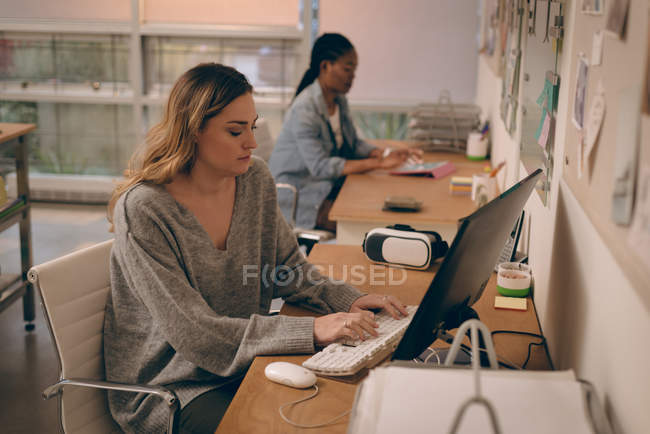 Ejecutiva femenina trabajando en computadora en la oficina - foto de stock