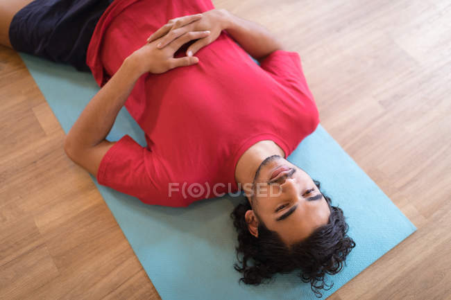 Junger Mann meditiert in Fitnessclub — Stockfoto