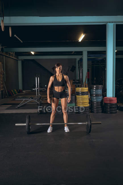 Fit femme prête à soulever la barre dans la salle de gym — Photo de stock