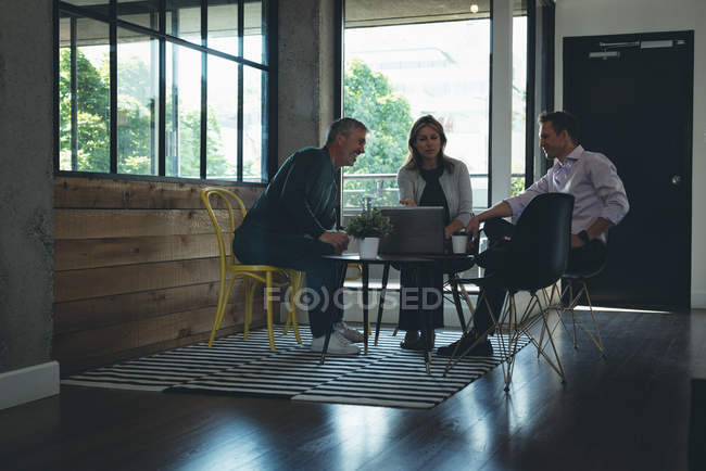 Бізнес колегами, обговорювати над ноутбук в офісі — стокове фото