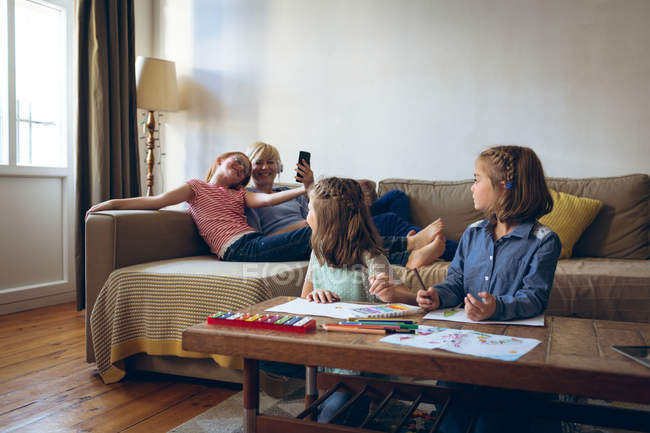 Kinder interagieren mit Mutter im heimischen Wohnzimmer — Stockfoto