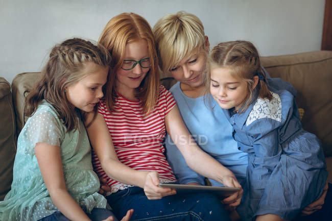 Sorrindo mãe e seus filhos usando tablet digital em casa — Fotografia de Stock