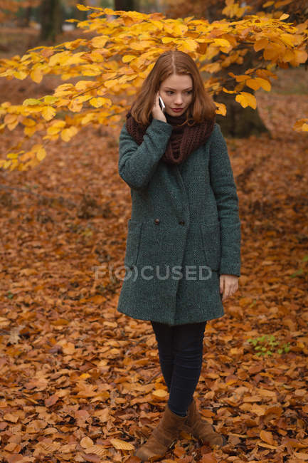 Frau telefoniert im Herbst im Park — Stockfoto