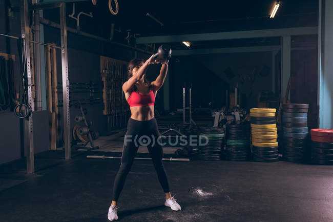 Fitte Frau trainiert mit Kettlebell im Fitnessstudio — Stockfoto
