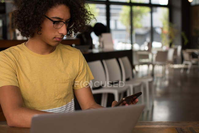 Молодий чоловік, використовуючи цифровий планшетний в кафетерії — стокове фото