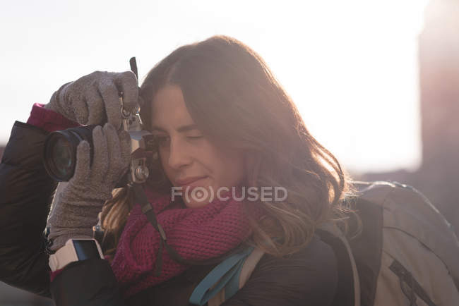 Молода жінка фотографується з фотоапаратом у сонячний день — стокове фото