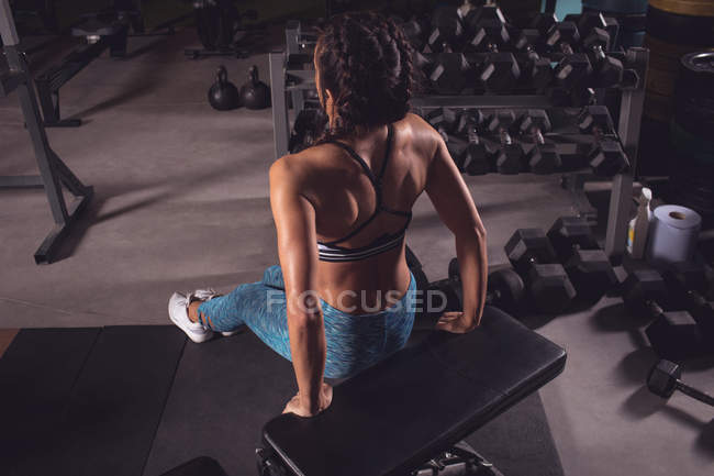 Подходящая женщина упражняется на тренажерной скамейке в тренажерном зале — стоковое фото