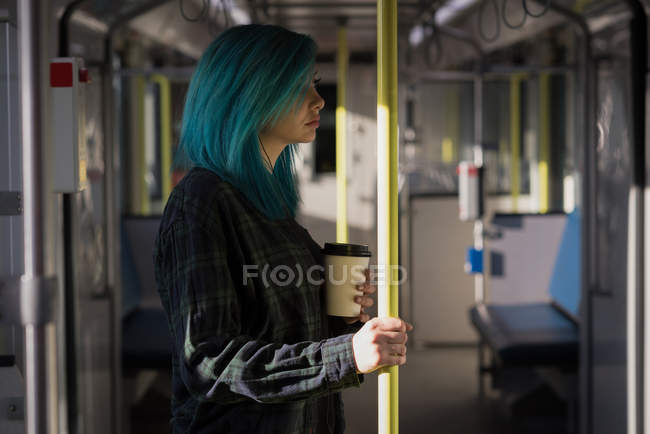 Femme élégante tenant tasse de café tout en voyageant dans le train — Photo de stock