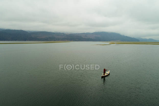 Homem turista viajando em barco de canoa em um lago — Fotografia de Stock