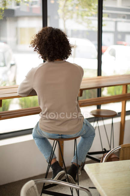 Rear view of thoughtful man sitting in cafeteria — Stock Photo