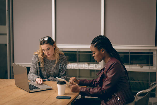 Женщины-руководители используют ноутбуки и цифровые планшеты в офисе — стоковое фото