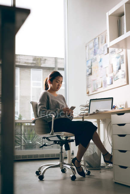 Жіночий керівник використовує мобільний телефон в офісі — стокове фото