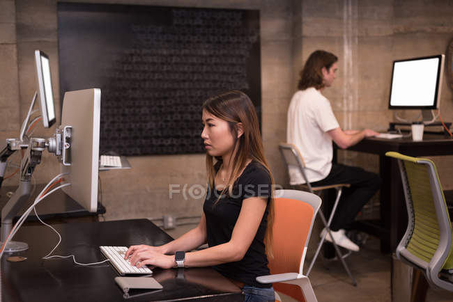 Бізнес-колеги, що працюють на комп'ютері за столом в офісі — стокове фото