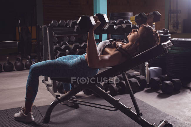 Fit woman exercising with dumbbells in the gym — Stock Photo
