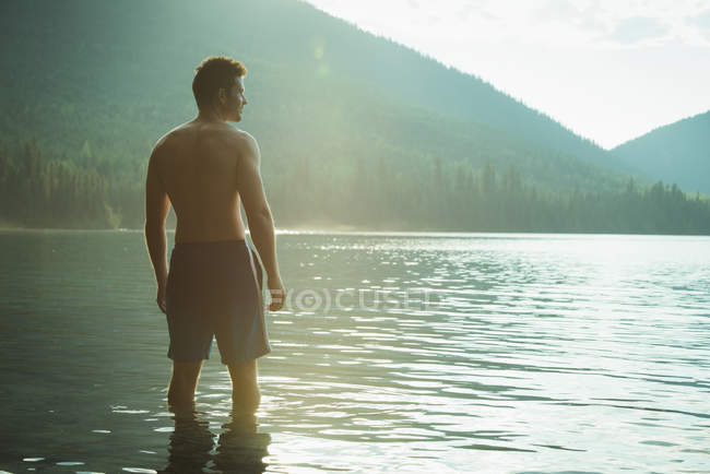 Задуманный человек, стоящий в озере — стоковое фото