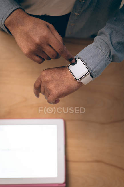 Overhead of executive using smartwatch in office — Stock Photo