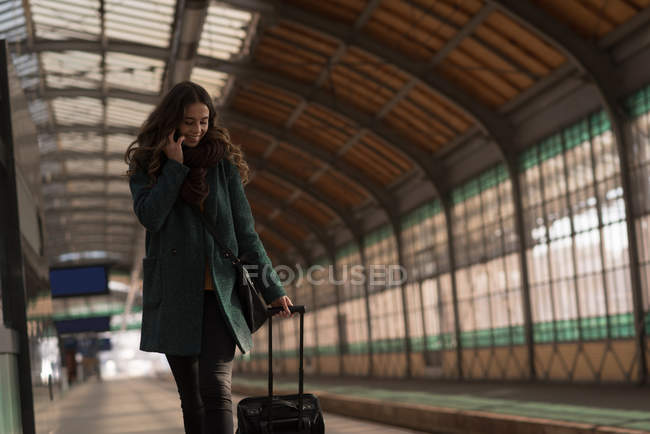 Mulher usando um telefone celular na estação ferroviária — Fotografia de Stock